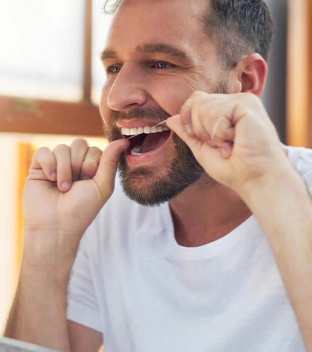 Patient flossing their dental implant
