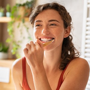Person brushing teeth carefully around dental implants
