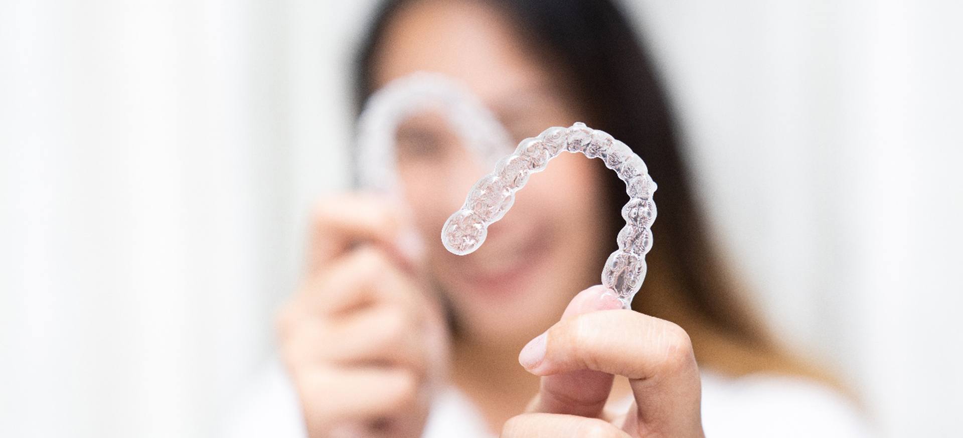 Closeup of patient holding clear aligners