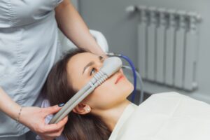 Dentist putting nitrous oxide mask over patient's nose